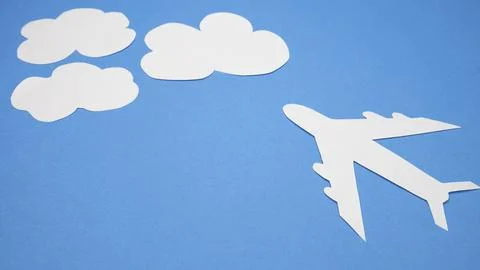 Paper plane in the clouds on a blue background. Concept of flight, travel. Copy Stock Photos