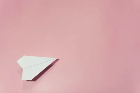 Paper plane fly, throws hearts in the word love, pink background. stop motion. Stock Footage 168562573