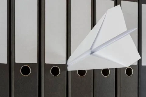 Paper plane stuck between folders Stock Photos