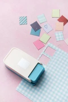 Paper punch creating decorative elements from colorful paper pieces Foto stock