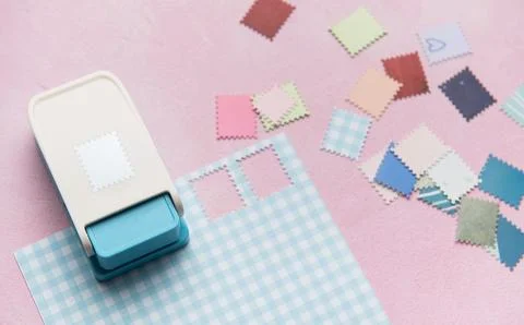 Paper punch creating decorative elements from colorful paper pieces Stock Photos