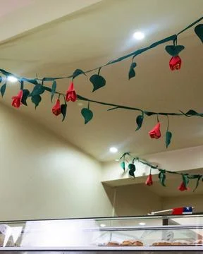 Paper roses dangle from ceiling strings Stockfoto's
