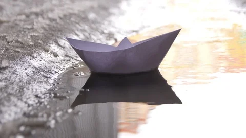 Paper Ship Floating in the Wind in the Puddle Stock Footage 105263609