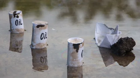 A paper ship with oil barrels explode s from their leakage Stock Footage 108635750