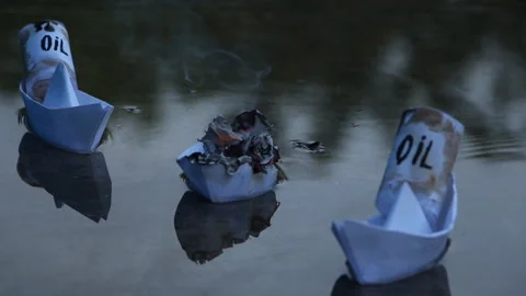 A paper ship with oil barrels explodes from their leakage Stock Footage 111649461