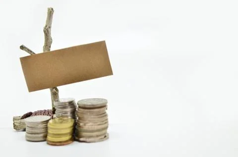 Paper sign board with stack of coins Foto stock