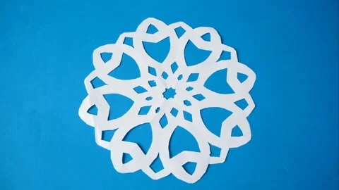 Paper snowflake on blue background, handmade new year decoration, stop motion Stock Footage 143858129