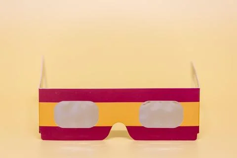 Paper solar eclipse glasses on yellow background Stock Photos
