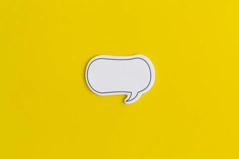 Paper speech bubble on a yellow background. Top view with copy space. Flat la Stock Photos
