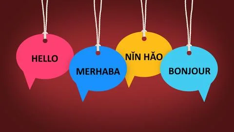 Paper speech bubbles with greetings in different languages hanging on dark .. Stock Photos