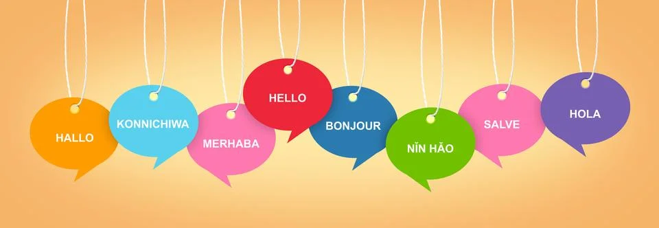 Paper speech bubbles with greetings in different languages hanging on pale .. Stock Photos