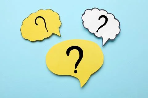 Paper speech bubbles with question marks on light blue background, flat lay Stock Photos