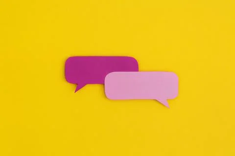 Paper speech bubbles on a yellow background. Top view with copy space. Flat l Stock Photos