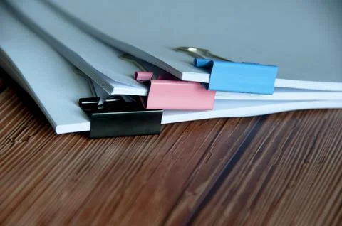 Paper stack of clipped pile of documents on wooden desk. Copy space Stock Photos