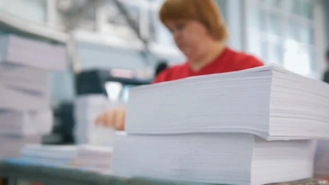 Paper stack in front of female worker sorting a papers in the typography Stock Footage 89621842