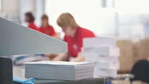 Paper stack in front of women working in typography - de-focused Stock Footage 88901481