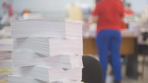 Paper stack in front of worker in the typography Stock Photos