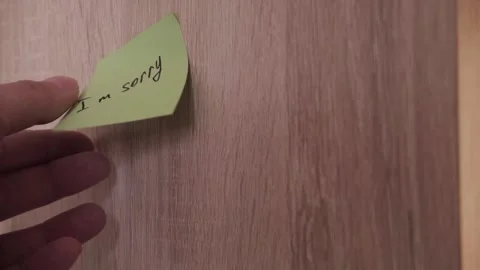 Paper sticker with the text I am sorry on a wooden surface background. Video Stock Footage 334829839