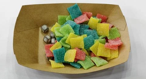 A paper tray filled with assorted square sugar‑coated candies Stock Photos