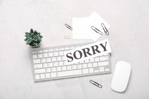 Paper with word SORRY, notes and computer keyboard on white grunge background Stock Photos