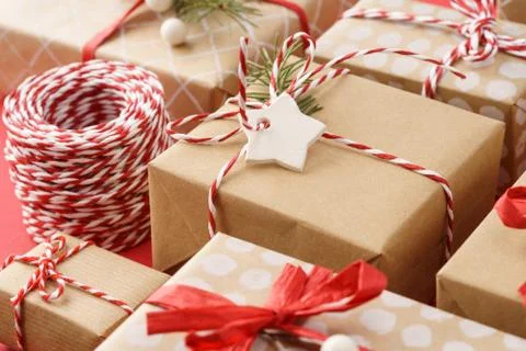 Paper wrapped gift boxes decorated with red ribbon and twine. Stock Photos