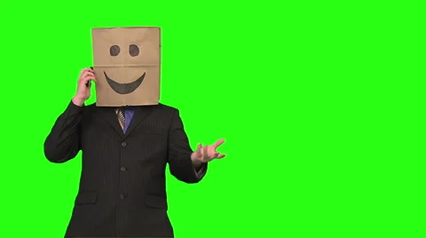 Paperbag man using a cellphone. medium shot. green background Stock Footage 49863318