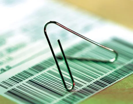 Paperclip on bill with bar code Fotos de archivo