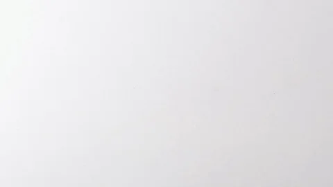 Paperclips drop onto a white surface in slow motion Stock Footage 117349980