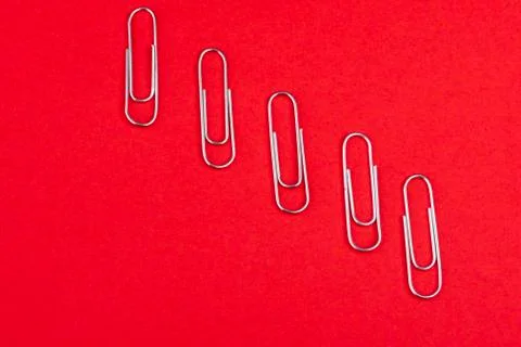 Paperclips individually placed from above on red background Stock Photos