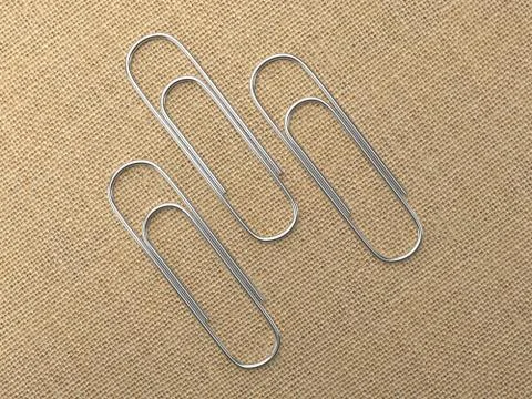 Paperclips laying on canvas Illustrazione stock
