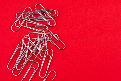 Paperclips mixed up on a red background Foto stock