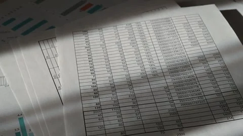 Papers with charts and graphs are organized on a table in an office. Natural Stockbeeldmateriaal 337555848