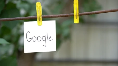 Papers with words Google and China hanging on rod. Man hand fasten word on right Stock Footage 108775044