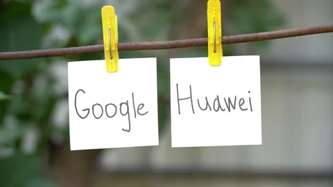 Papers with the words Google and Huawei on yellow clothespins hanging on rod. Stock Footage 108775054
