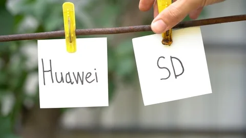 Papers with words Huawei and SD. Man’s hand use lighter ignites word on right Stock Footage 108775813