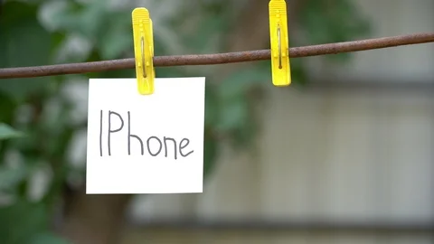 Papers with words IPhone and China hanging on rod. Man hand hook word on right. Stock Footage 108774441