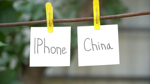 Papers with words IPhone and China on rope. Man hand take away word on right. Stock Footage 108774630