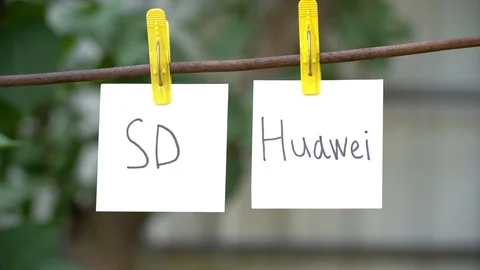 Papers with words SD and Huawei on rope. Man hand take away word on right. Stock Footage 108775287
