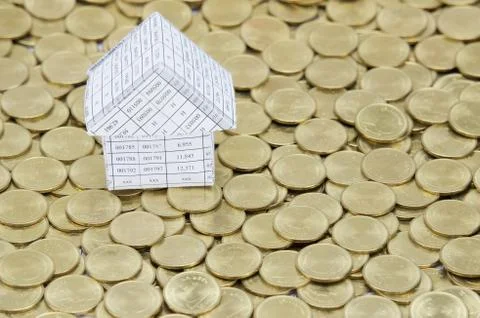 Paperwork as house on stack of gold coins Stock Photos