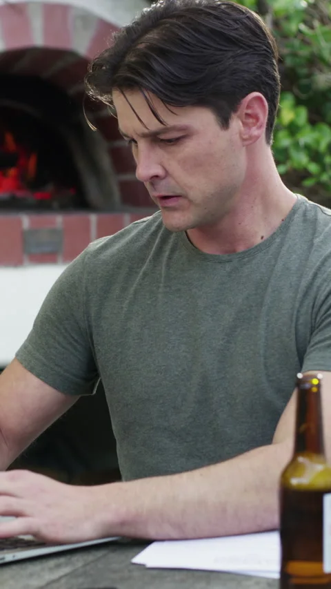Paperwork, laptop and man with beer in backyard, online tax application and Video stock 327372049