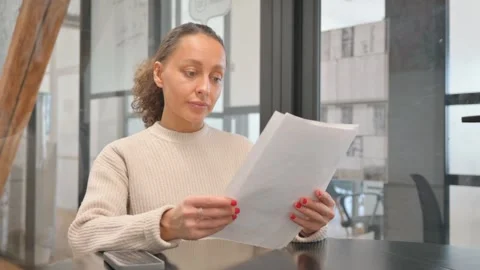 Paperwork by Multiracial Woman Reading Documents at Workspace Video stock 303397196