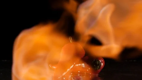 Paprika getting flamed on a wet surface in slow motion Stock Footage 88807027