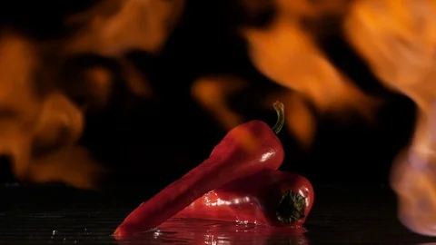 Paprika getting flamed on a wet surface in slow motion Stock Footage 88807111