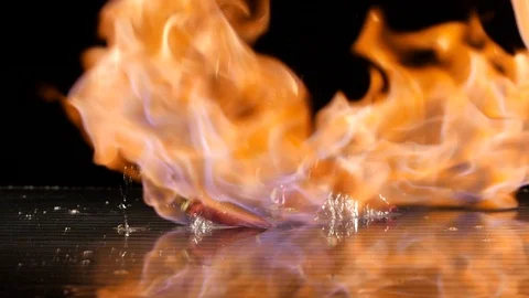 Paprika getting flamed on a wet surface in slow motion Stock Footage 88807595
