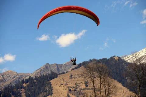 A Para Glider flies low on the hills in Himachal Pradesh India Stock Photos