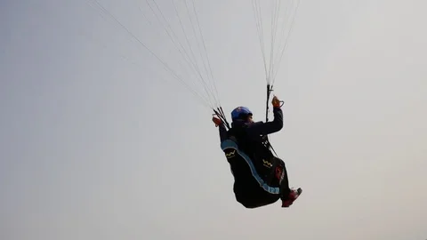 Para-glider flies sitting in harness at the beach Video stock 79627716