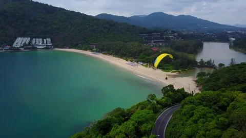 Para-glider make turn at end of hill slope, nice tropical beach on background Stock Footage 78533144
