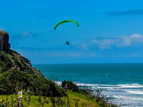 Para glider soars over the beach, waves and hills at Murawai Beach, Auckland, 写真素材