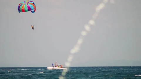 Para gliding sailing behind power speed boat floating against cloudy sky at Stock Footage 172210172