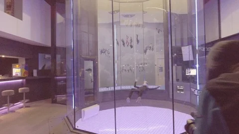 A parabolic chamber indoor skydiving simulator allows people to float as if in a Vidéo 106627984